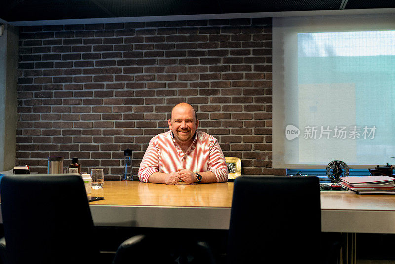 Portrait of a smiling entrepreneur or businessman at office desk